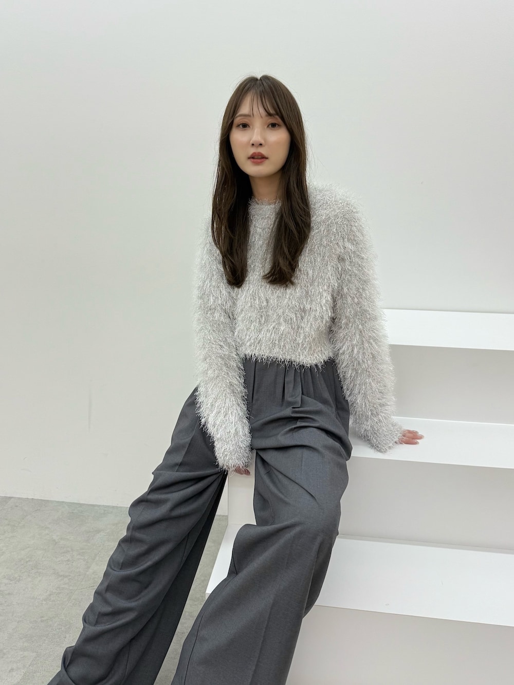 グレー系のニット/セーター、グレー系のその他パンツを着用したレディースの秋コーディネートの5枚目の写真