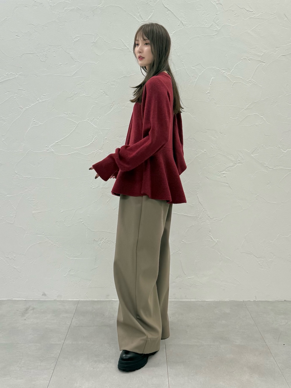 レッド系のニット/セーター、ブラウン系のその他パンツを着用したレディースの秋コーディネートの2枚目の写真