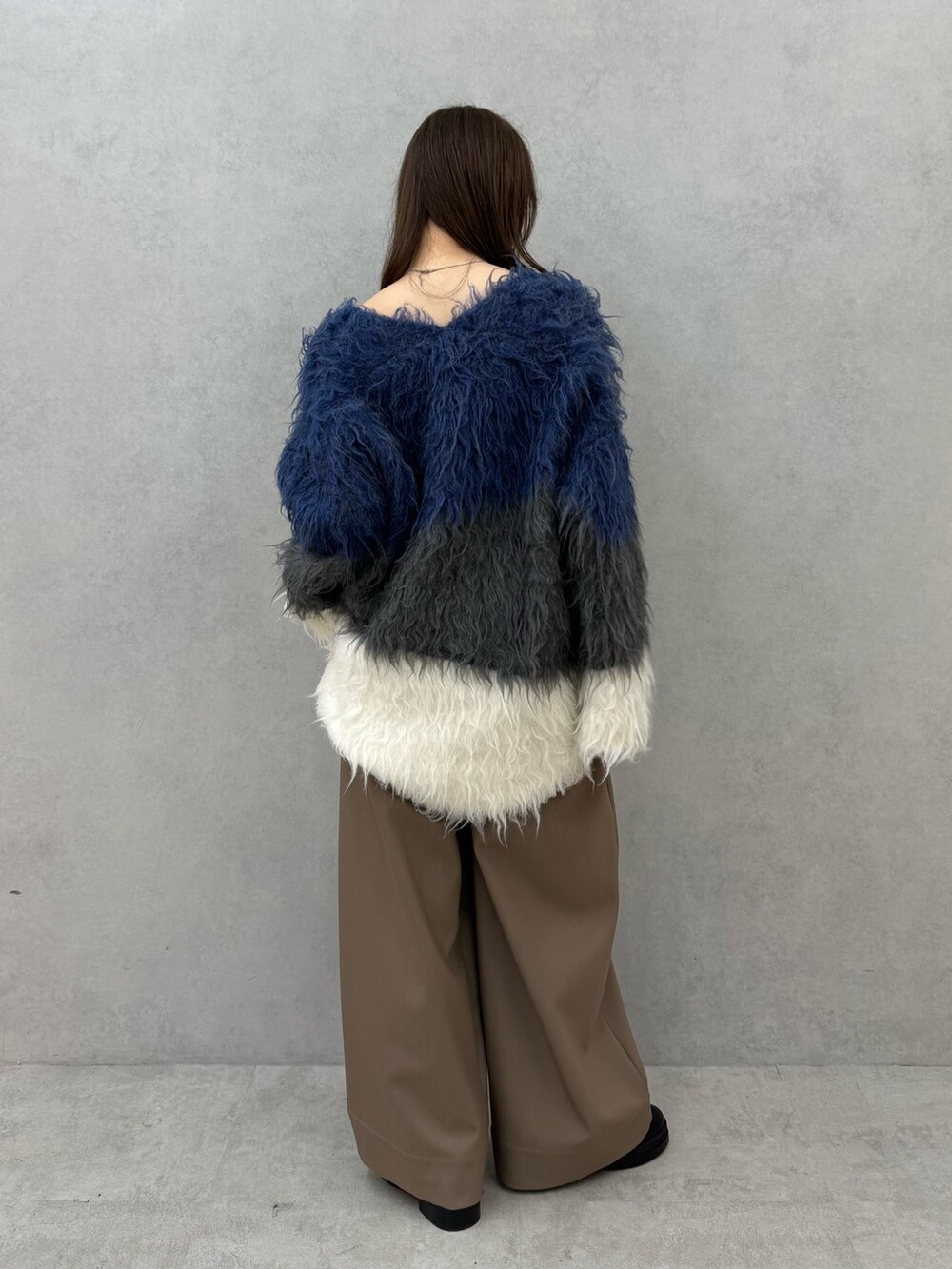 ブルー系のニット/セーター、ブラウン系のその他パンツを着用したレディースの秋コーディネートの4枚目の写真