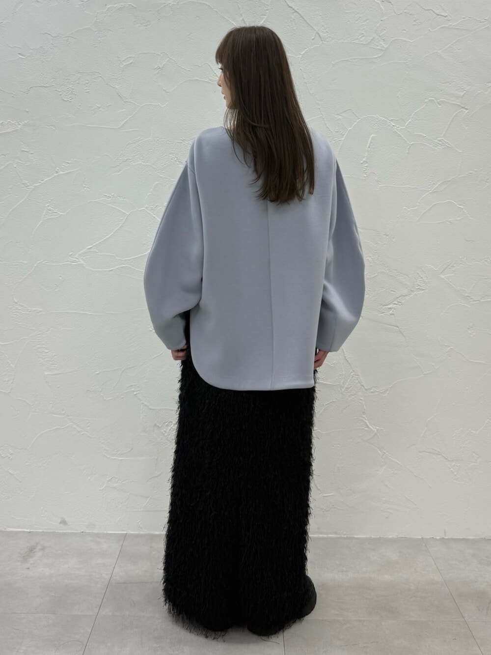 ブルー系のTシャツ/カットソー、ブラック系のスカートを着用したレディースの秋コーディネートの4枚目の写真