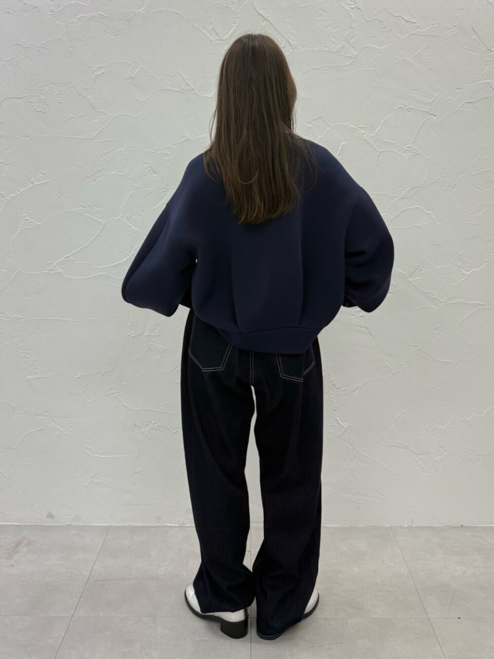 ブルー系のTシャツ/カットソー、シルバー系のパンプス、ブルー系のデニムパンツを着用したレディースの秋コーディネートの4枚目の写真