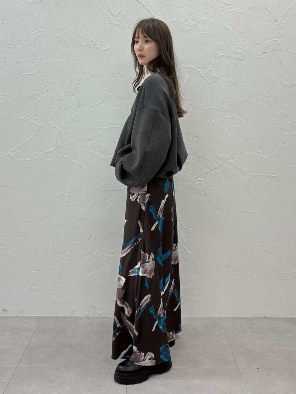 グレー系のTシャツ/カットソー、ブラウン系のスカートを着用したレディースの秋コーディネートの3枚目の写真