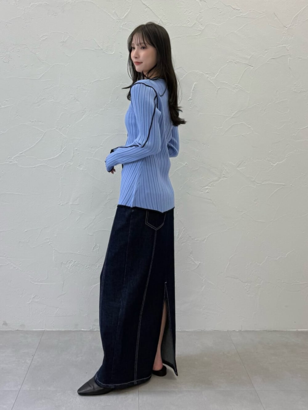 ブラック系のパンプス、ブルー系のニット/セーター、ブルー系のスカートを着用したレディースの春コーディネートの2枚目の写真