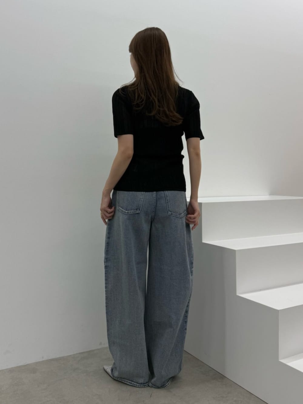 ブルー系のデニムパンツ、シルバー系のパンプス、ブラック系のニット/セーターを着用したレディースの春コーディネートの3枚目の写真
