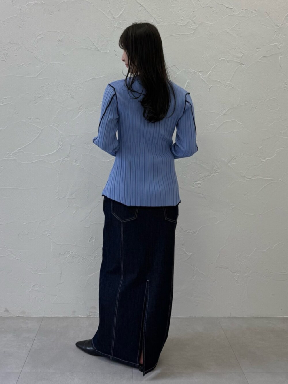 ブラック系のパンプス、ブルー系のニット/セーター、ブルー系のスカートを着用したレディースの春コーディネートの3枚目の写真