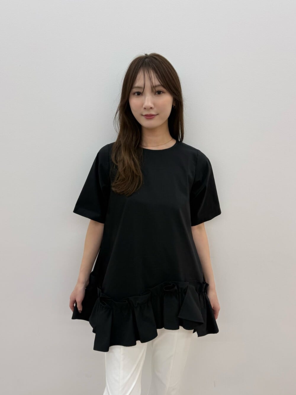 ホワイト系のその他パンツ、ブラック系のパンプス、ブラック系のTシャツ/カットソーを着用したレディースの春コーディネートの5枚目の写真