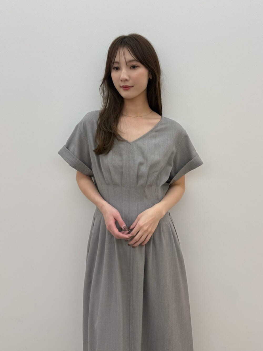 ブラック系のパンプス、ベージュ系のワンピースを着用したレディースの春コーディネートの6枚目の写真