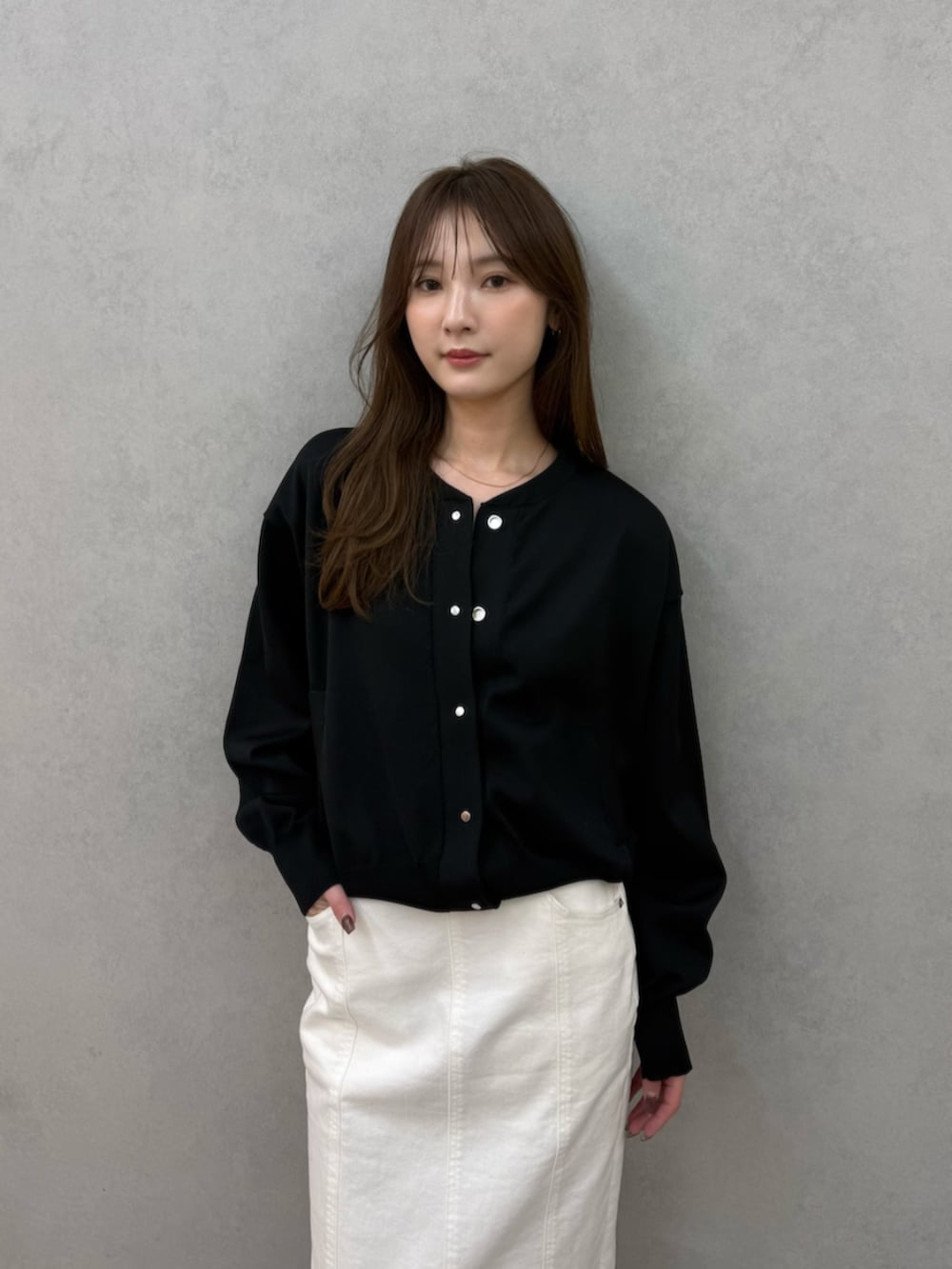 ブラック系のカーディガン/ボレロ、ブラック系のパンプス、ホワイト系のスカートを着用したレディースの春コーディネートの4枚目の写真