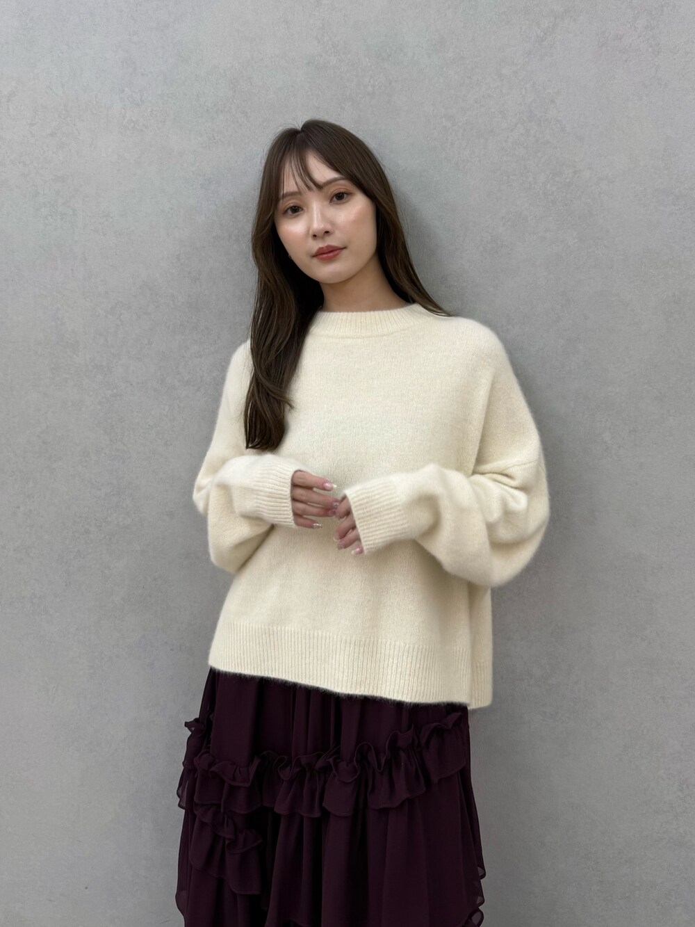 ホワイト系のチェスターコート、ホワイト系のニット/セーター、レッド系のスカートを着用したレディースの秋コーディネートの8枚目の写真