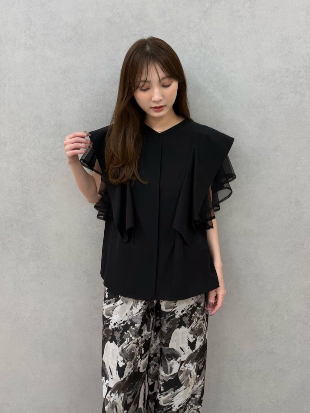 ブラック系のパンプス、ブラック系のシャツ/ブラウス、ブラック系のその他パンツを着用したレディースの春コーディネートの6枚目の写真