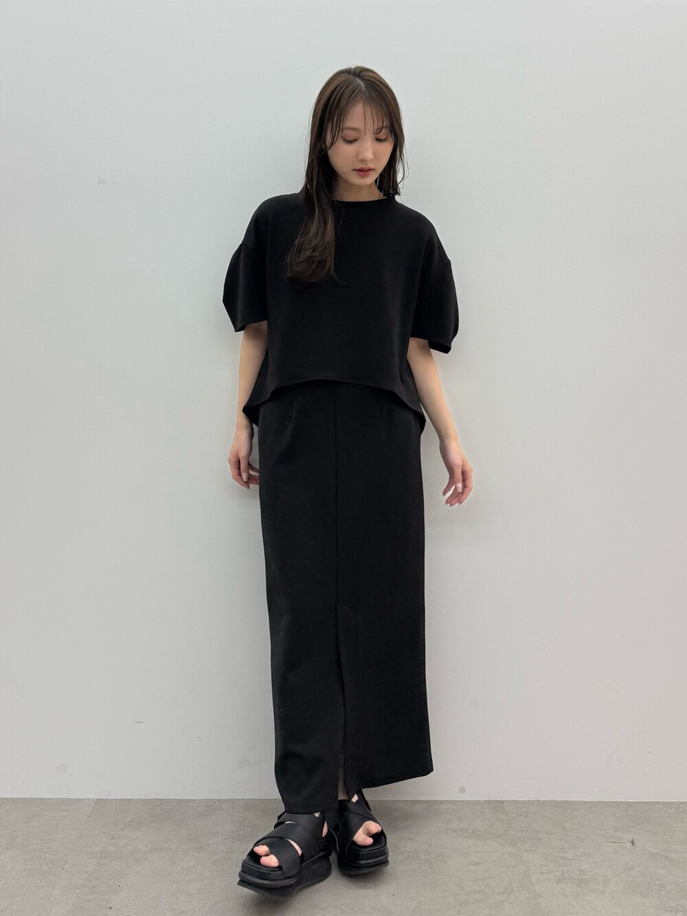 ブラック系のTシャツ/カットソー、ブラック系のスカートを着用したレディースの春コーディネートの2枚目の写真