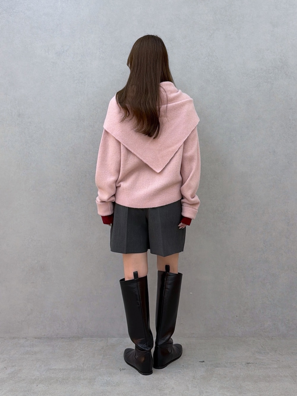 ピンク系のニット/セーター、グレー系のその他パンツ、ブラック系のブーツを着用したレディースの夏コーディネートの3枚目の写真
