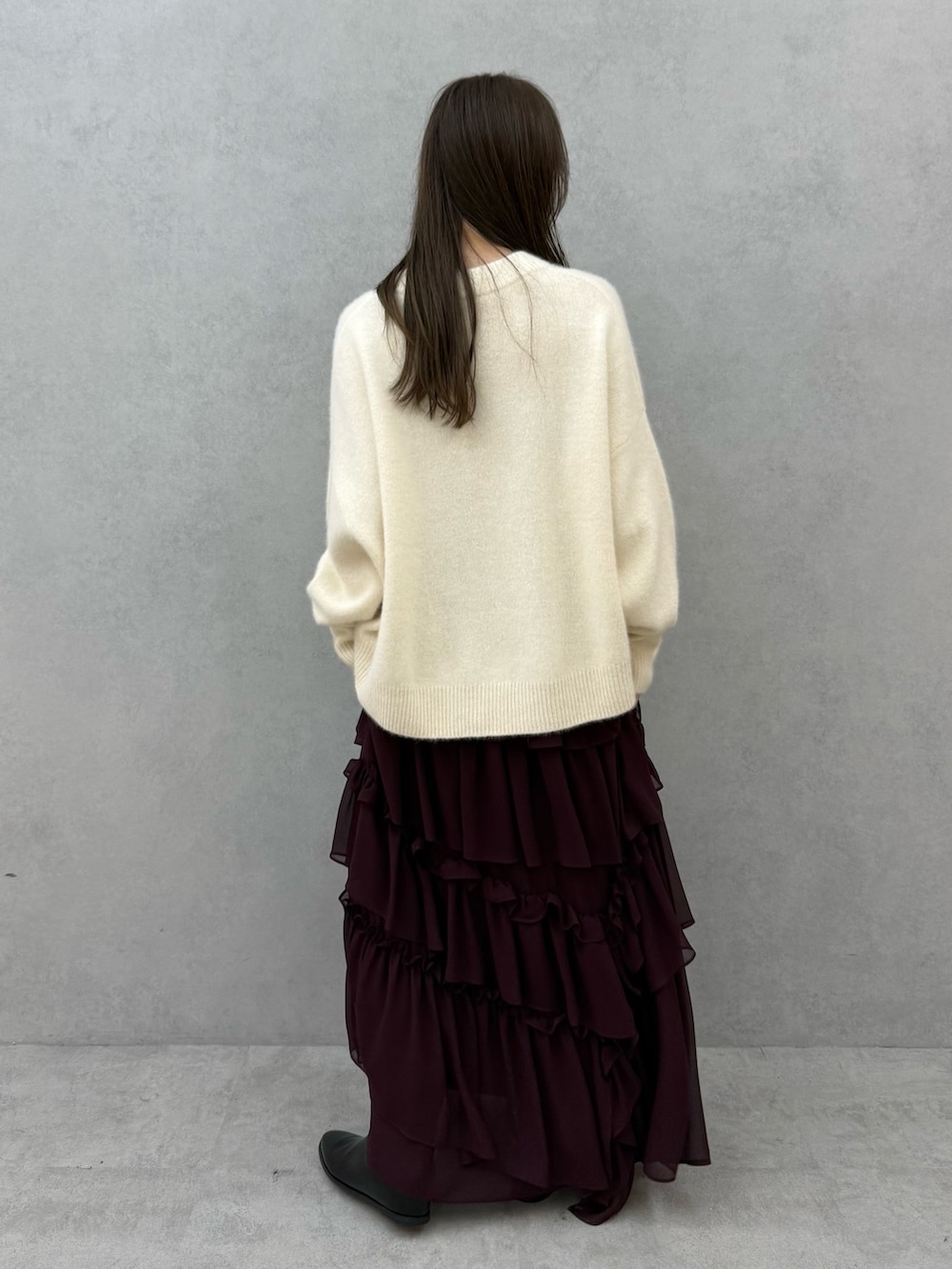 ホワイト系のチェスターコート、ホワイト系のニット/セーター、レッド系のスカートを着用したレディースの秋コーディネートの7枚目の写真