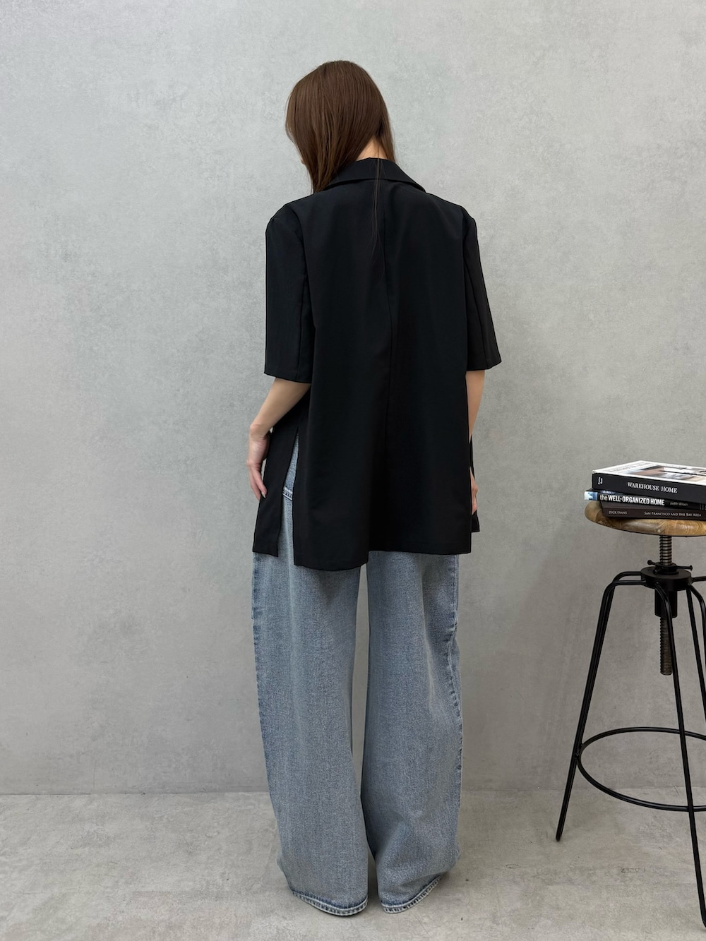 ブルー系のデニムパンツ、ブラック系のテーラードジャケット、シルバー系のパンプスを着用したレディースの春コーディネートの3枚目の写真