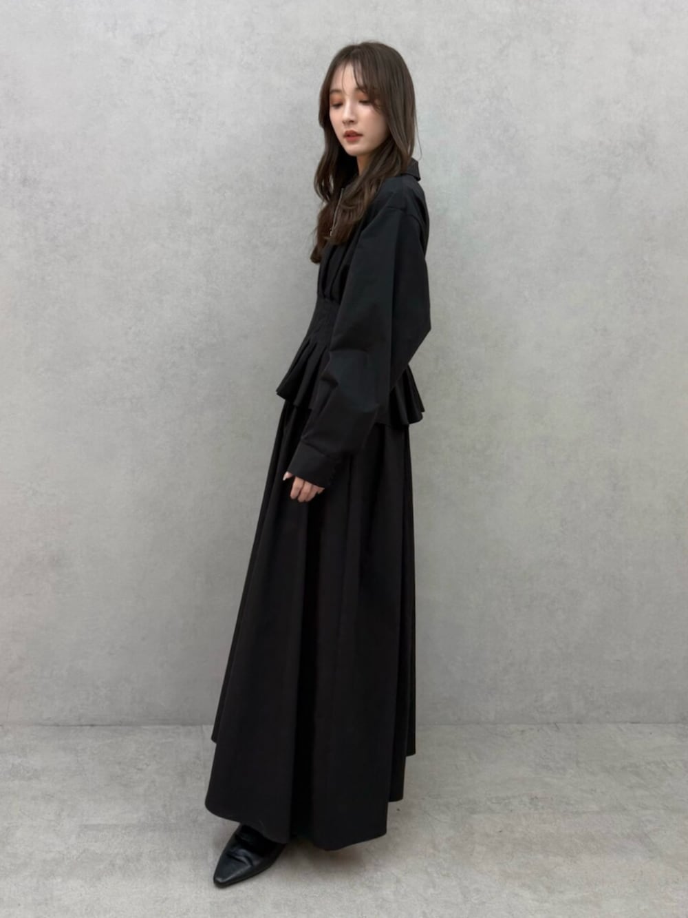 ブラック系のパンプス、ブラック系のワンピースを着用したレディースの冬コーディネートの2枚目の写真