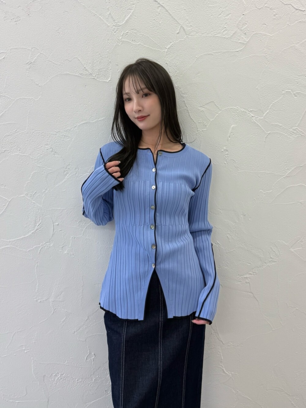 ブラック系のパンプス、ブルー系のニット/セーター、ブルー系のスカートを着用したレディースの春コーディネートの4枚目の写真