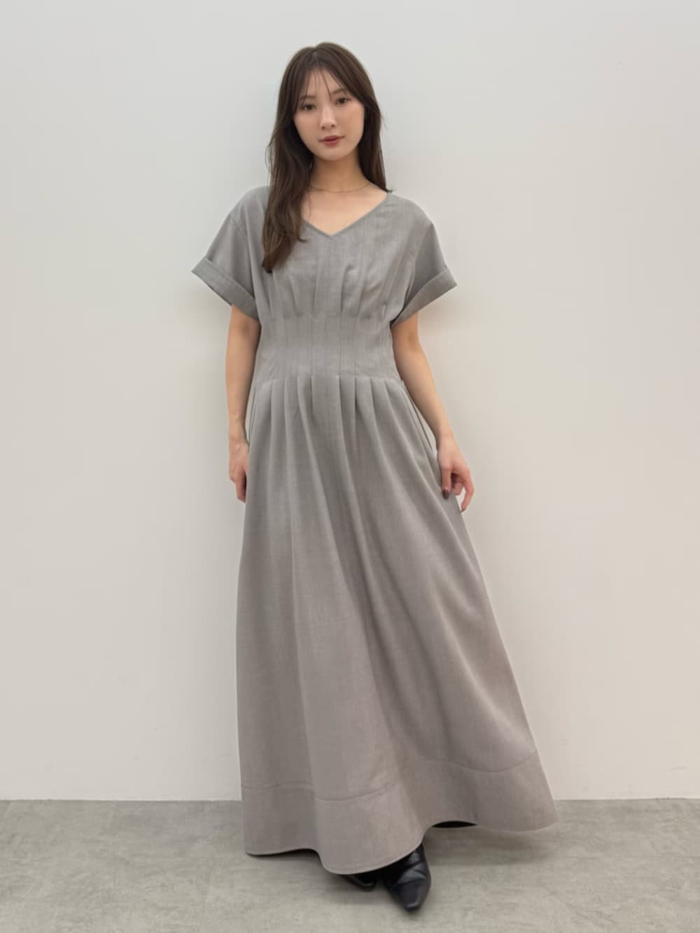 ブラック系のパンプス、ベージュ系のワンピースを着用したレディースの春コーディネートの2枚目の写真