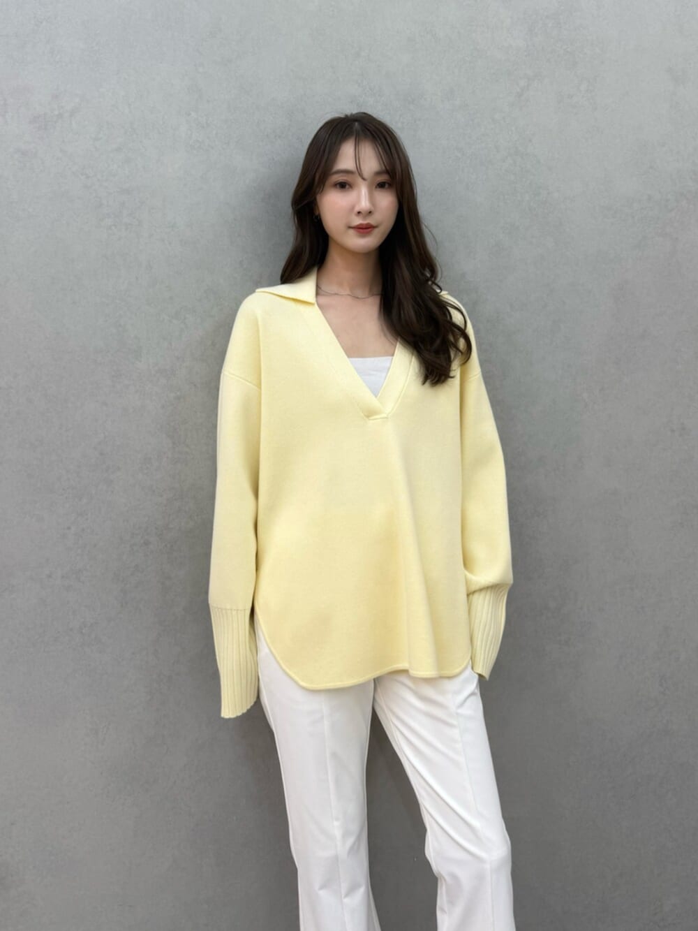 イエロー系のニット/セーター、ホワイト系のその他パンツ、ホワイト系のキャミソールを着用したレディースの冬コーディネートの4枚目の写真