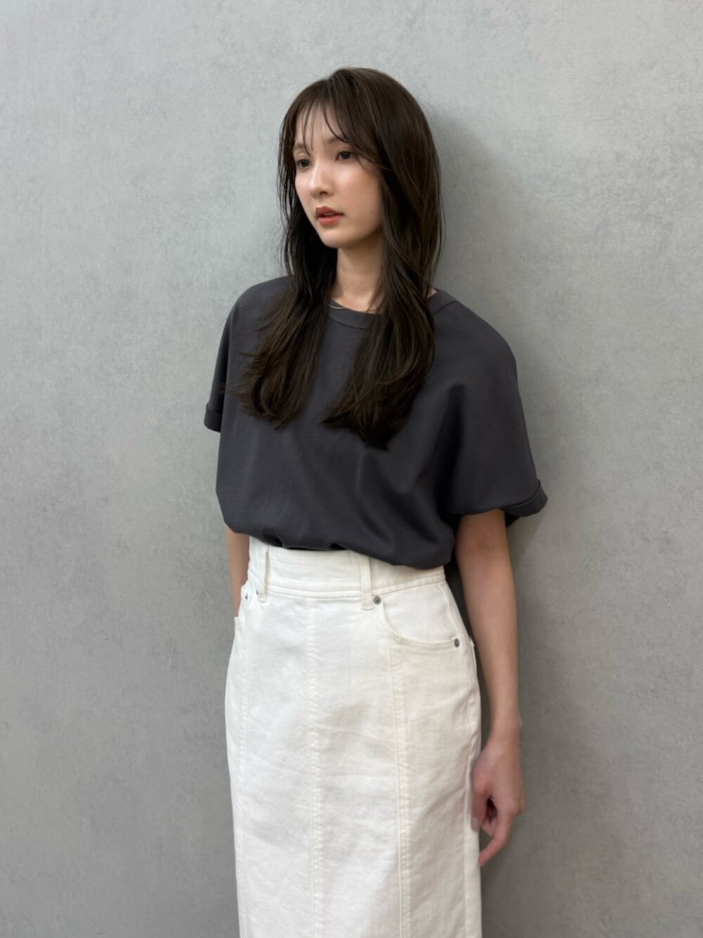 ホワイト系のスカート、ホワイト系のサンダル、グレー系のTシャツ/カットソーを着用したレディースの春コーディネートの4枚目の写真