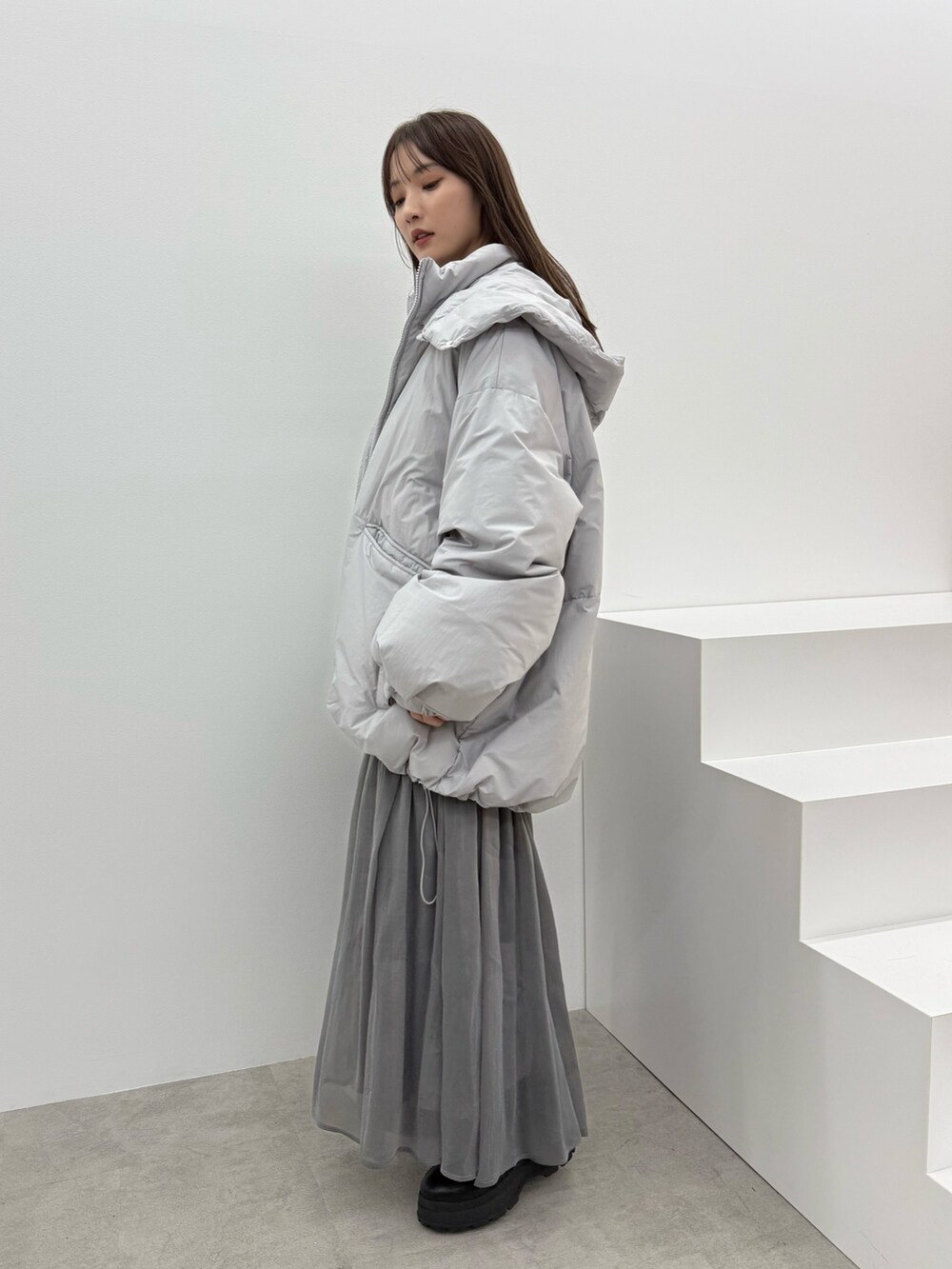 グレー系のダウンジャケット/コート、ブラック系のワンピースを着用したレディースの秋コーディネートの3枚目の写真