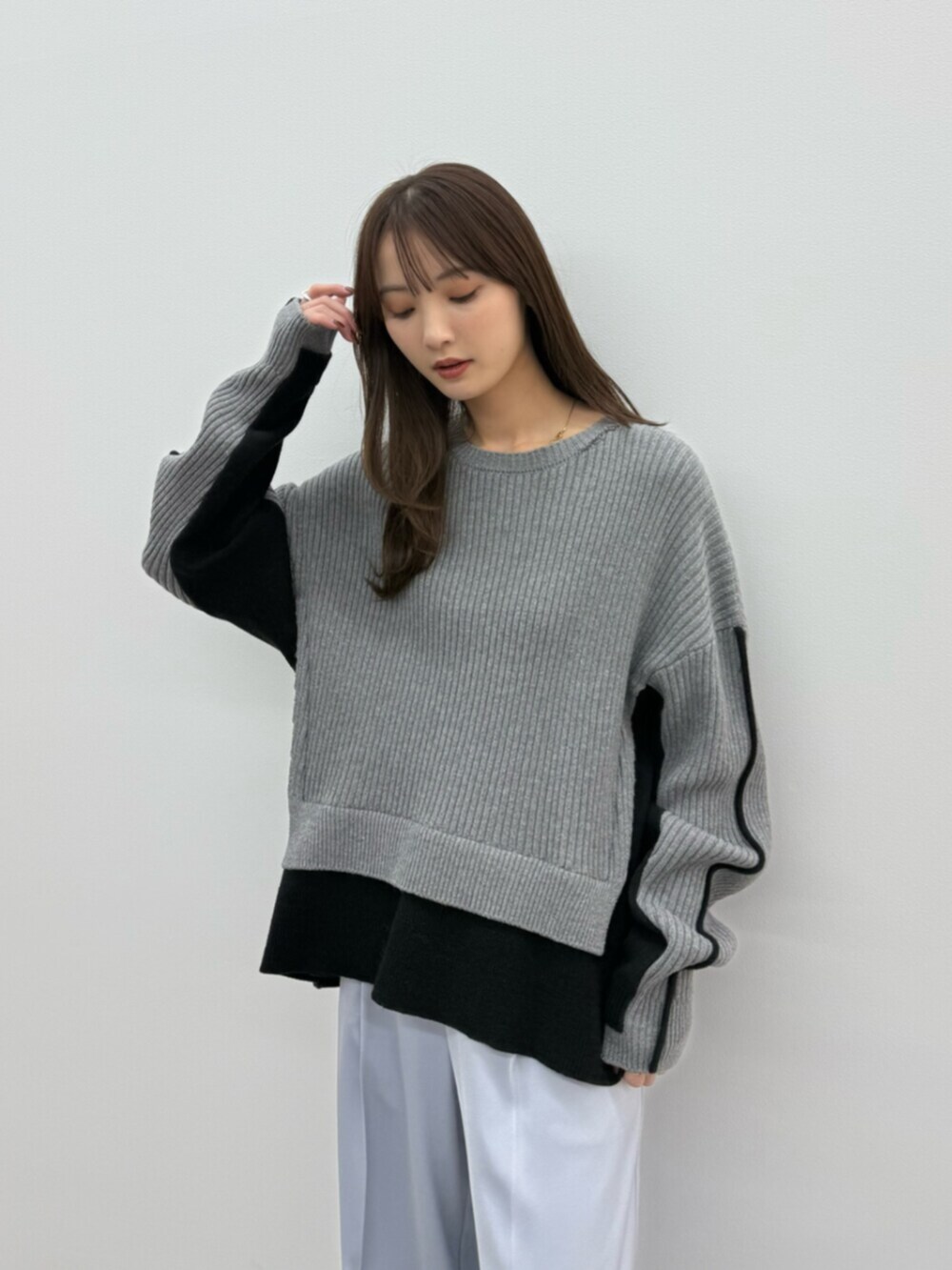 グレー系のニット/セーター、ブルー系のその他パンツ、シルバー系のパンプスを着用したレディースの秋コーディネートの5枚目の写真