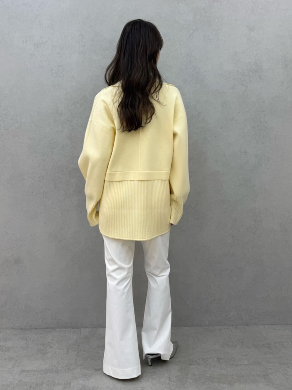 イエロー系のニット/セーター、ホワイト系のその他パンツ、ホワイト系のキャミソールを着用したレディースの冬コーディネートの3枚目の写真