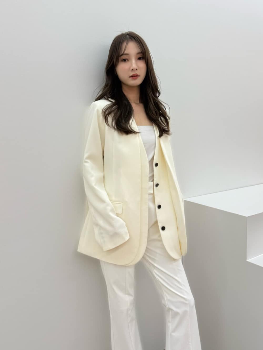 ホワイト系のその他パンツ、ホワイト系のノーカラージャケットを着用したレディースの冬コーディネートの2枚目の写真