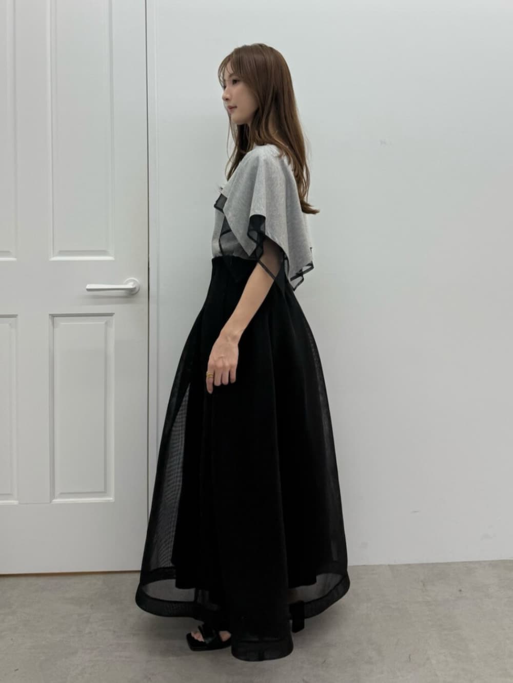 ブラック系のサンダル、グレー系のTシャツ/カットソー、ブラック系のスカートを着用したレディースの春コーディネートの2枚目の写真