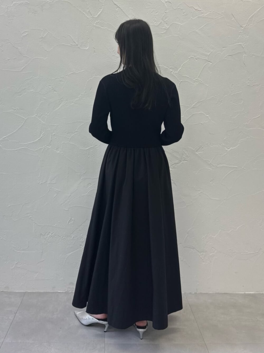 シルバー系のパンプス、ブラック系のワンピースを着用したレディースの春コーディネートの3枚目の写真