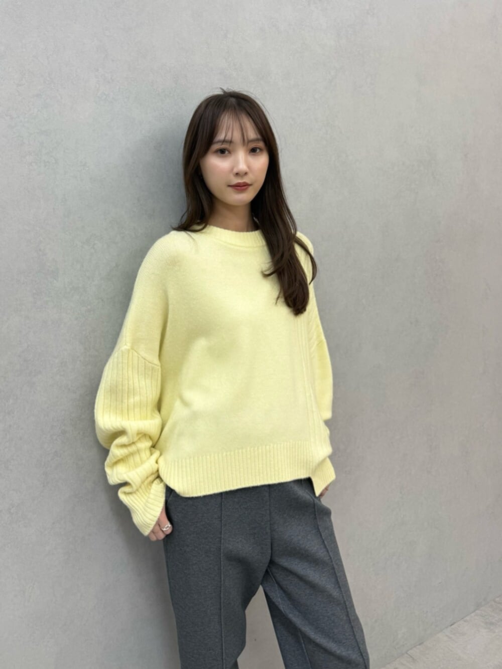 イエロー系のニット/セーター、グレー系のその他パンツ、シルバー系のパンプスを着用したレディースの秋コーディネートの5枚目の写真