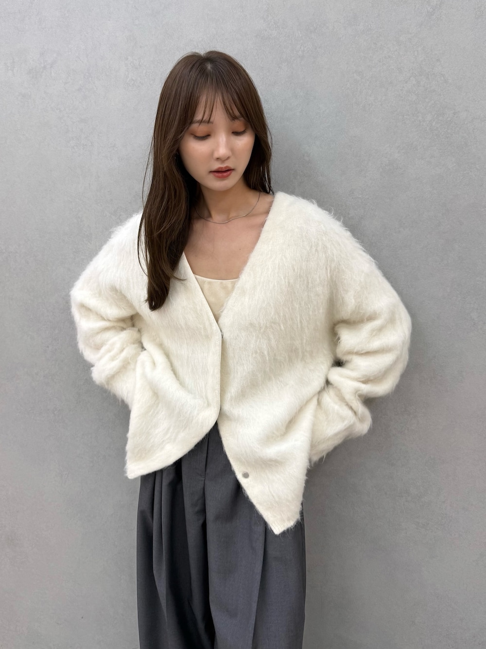 ホワイト系のカーディガン/ボレロ、グレー系のその他パンツ、ベージュ系のその他アウターを着用したレディースの秋コーディネートの6枚目の写真