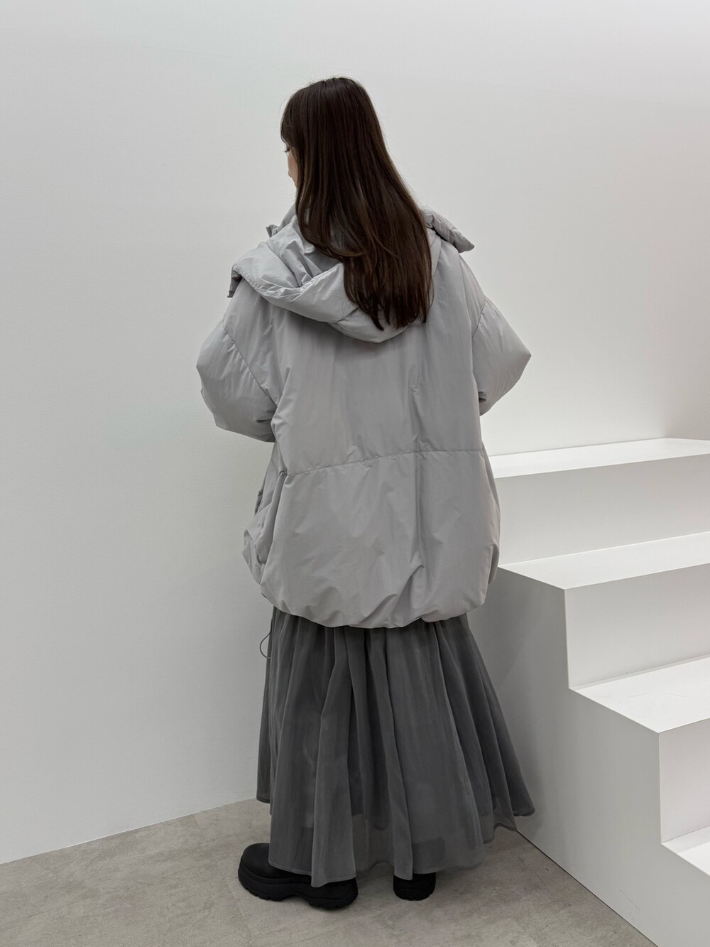 グレー系のダウンジャケット/コート、ブラック系のワンピースを着用したレディースの秋コーディネートの4枚目の写真