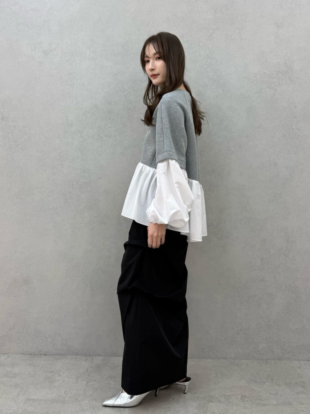 グレー系のTシャツ/カットソー、ブラック系のスカートを着用したレディースの冬コーディネートの2枚目の写真