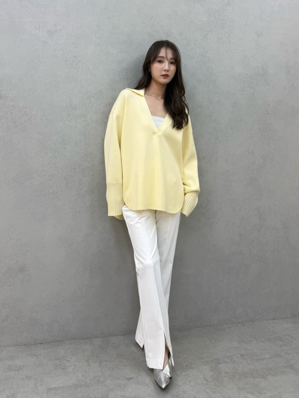イエロー系のニット/セーター、ホワイト系のその他パンツ、ホワイト系のキャミソールを着用したレディースの冬コーディネートの5枚目の写真