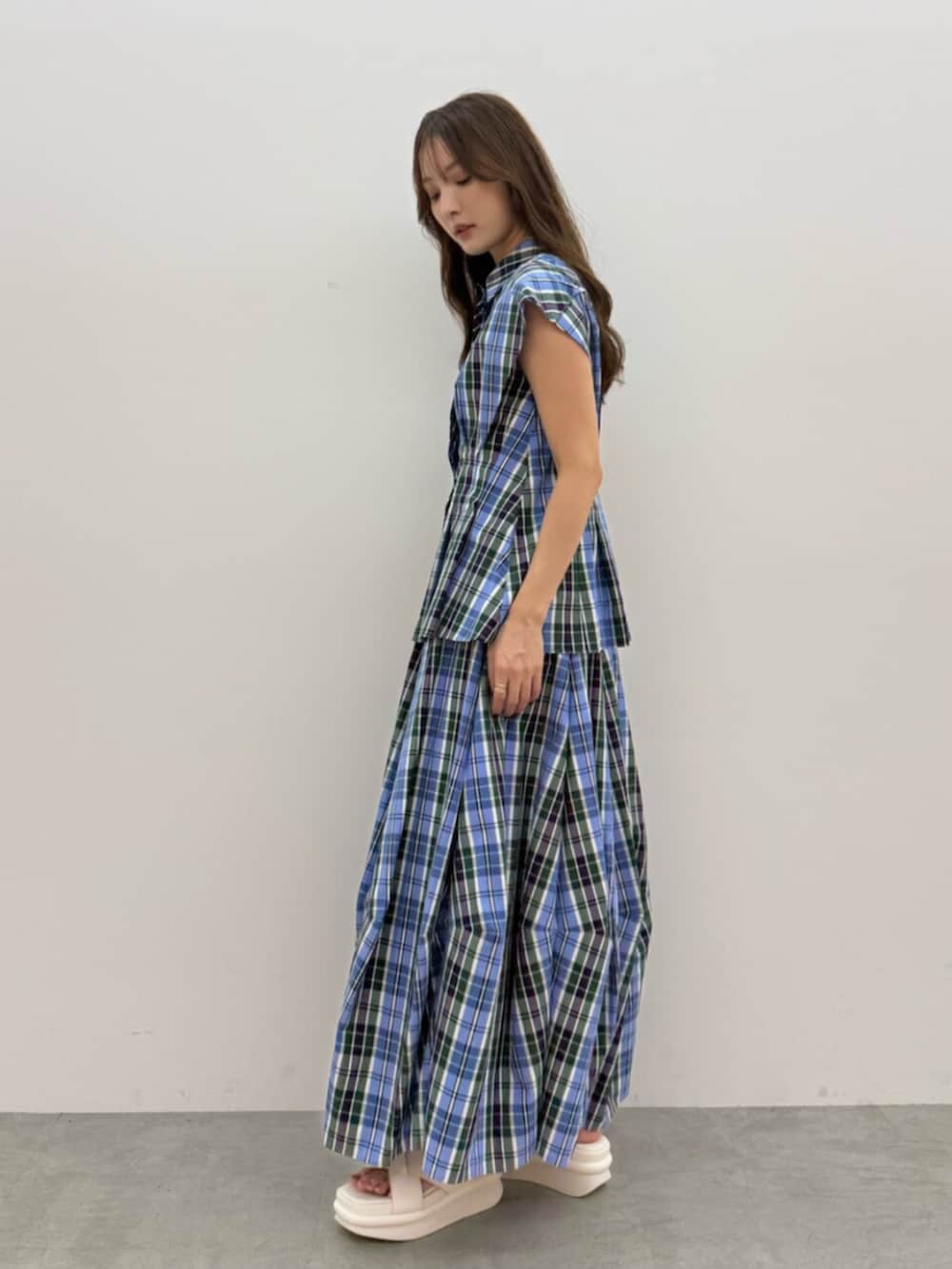 ブルー系のシャツ/ブラウス、ブルー系のスカート、ホワイト系のサンダルを着用したレディースの夏コーディネートの2枚目の写真