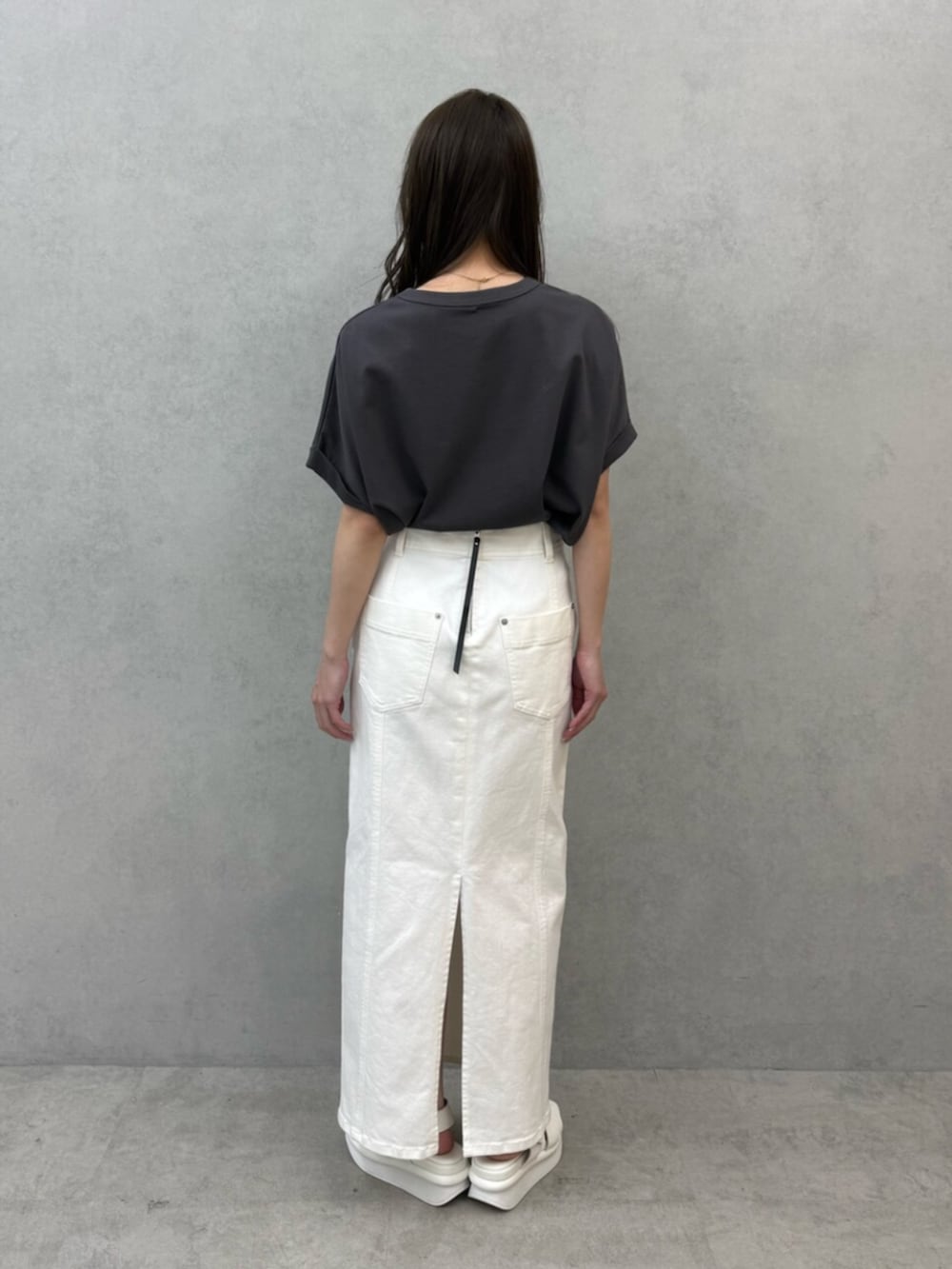 ホワイト系のスカート、ホワイト系のサンダル、グレー系のTシャツ/カットソーを着用したレディースの春コーディネートの3枚目の写真