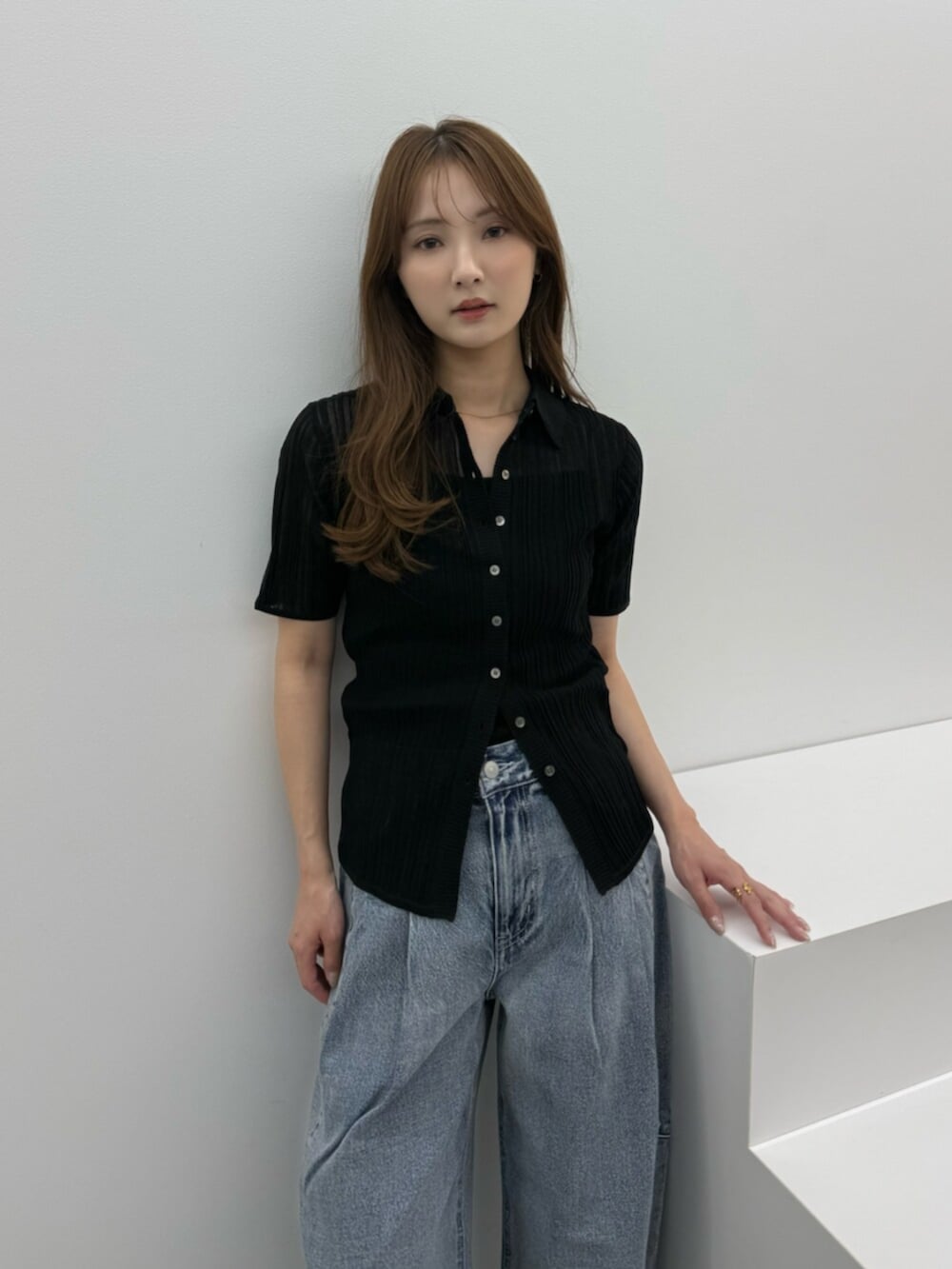 ブルー系のデニムパンツ、シルバー系のパンプス、ブラック系のニット/セーターを着用したレディースの春コーディネートの5枚目の写真