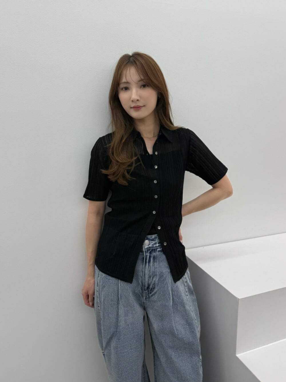 ブルー系のデニムパンツ、シルバー系のパンプス、ブラック系のニット/セーターを着用したレディースの春コーディネートの4枚目の写真