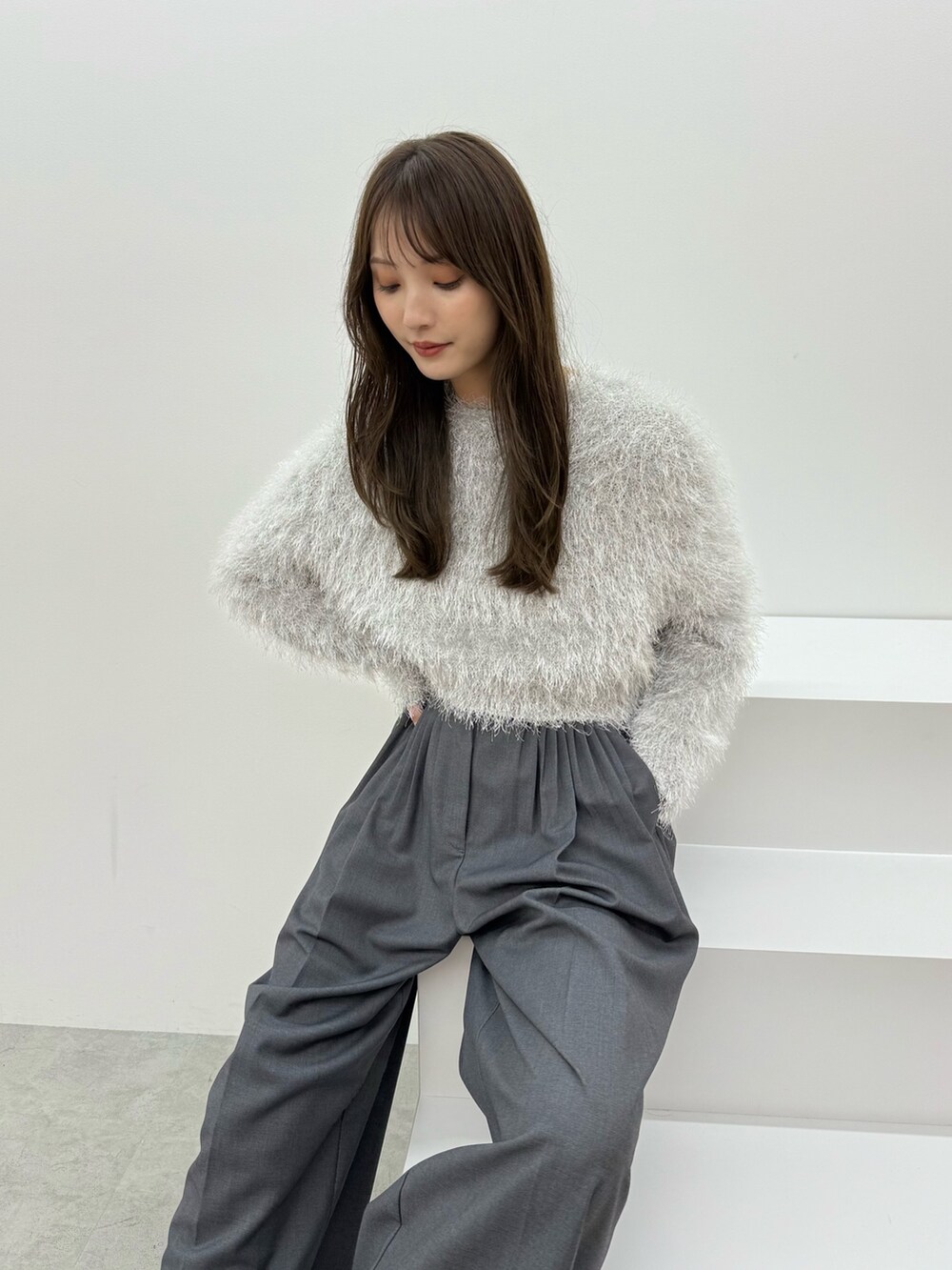 グレー系のニット/セーター、グレー系のその他パンツを着用したレディースの秋コーディネートの6枚目の写真