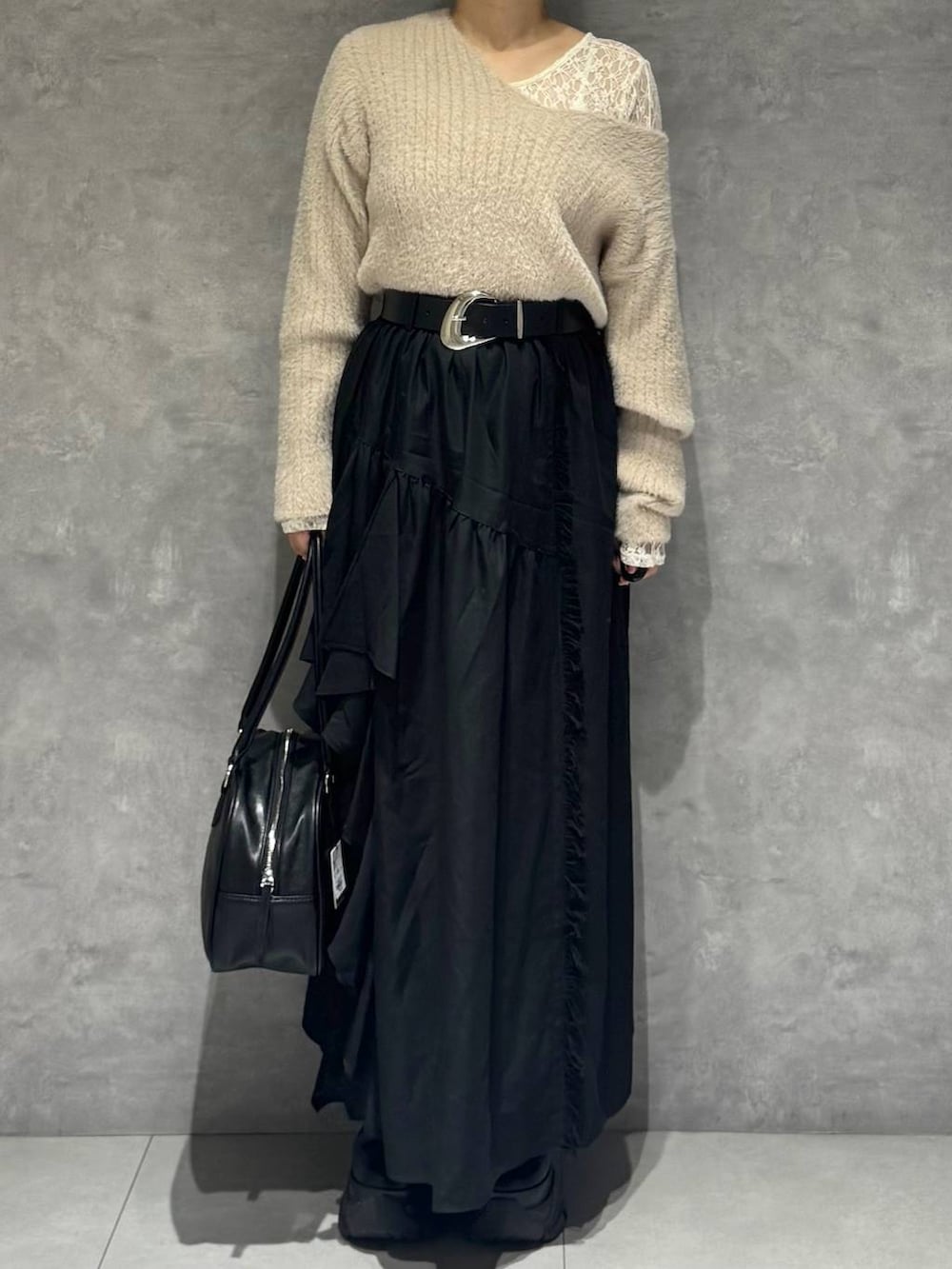 ブラック系のブーツ、ホワイト系のTシャツ/カットソー、ブラック系のボストンバッグを着用したレディースの秋コーディネートの2枚目の写真