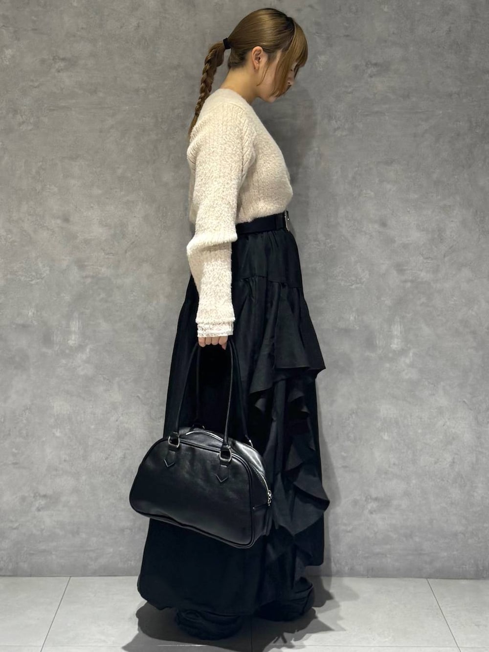 ブラック系のブーツ、ホワイト系のTシャツ/カットソー、ブラック系のボストンバッグを着用したレディースの秋コーディネートの4枚目の写真