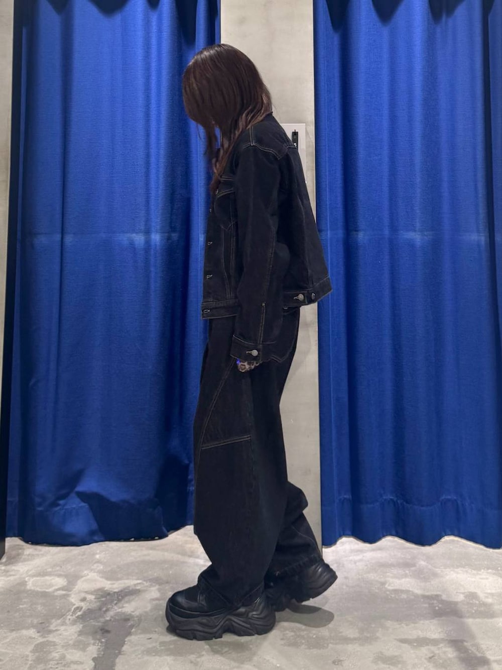 ブラック系のデニムパンツ、ブラック系のデニムジャケット、ブラック系のブーツを着用したレディースの夏コーディネートの6枚目の写真