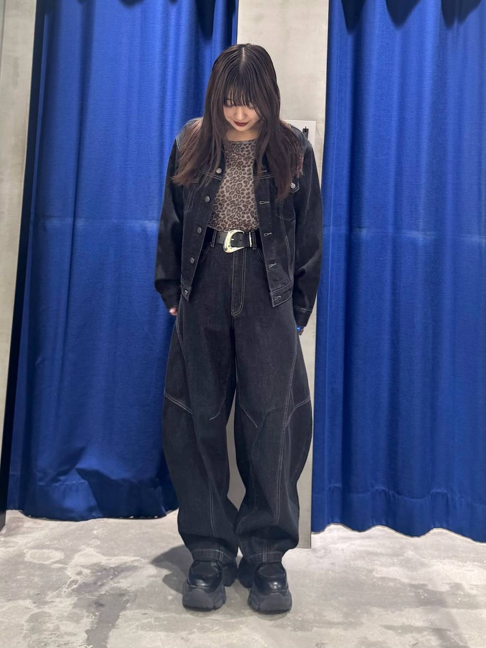 ブラック系のデニムパンツ、ブラック系のデニムジャケット、ブラック系のブーツを着用したレディースの夏コーディネートの3枚目の写真