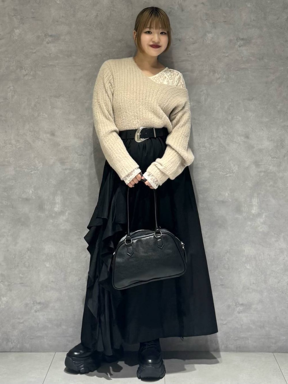 ブラック系のブーツ、ホワイト系のTシャツ/カットソー、ブラック系のボストンバッグを着用したレディースの秋コーディネートの3枚目の写真