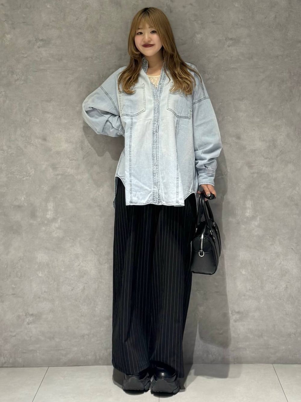 ブラック系のブーツ、ホワイト系のTシャツ/カットソー、ブラック系のボストンバッグを着用したレディースの冬コーディネートの7枚目の写真