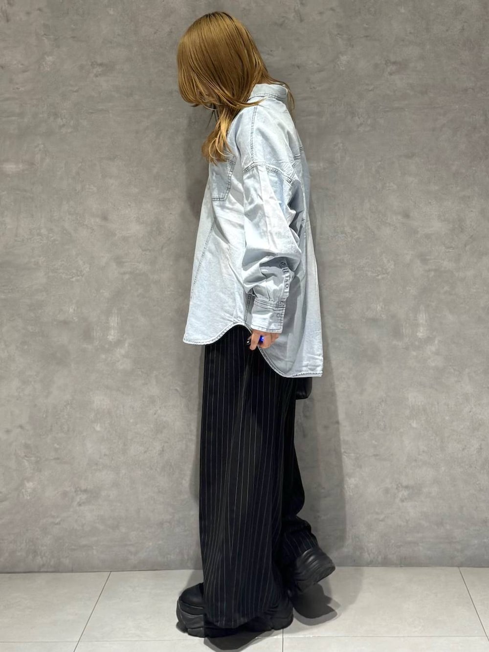 ブラック系のブーツ、ホワイト系のTシャツ/カットソー、ブラック系のボストンバッグを着用したレディースの冬コーディネートの6枚目の写真