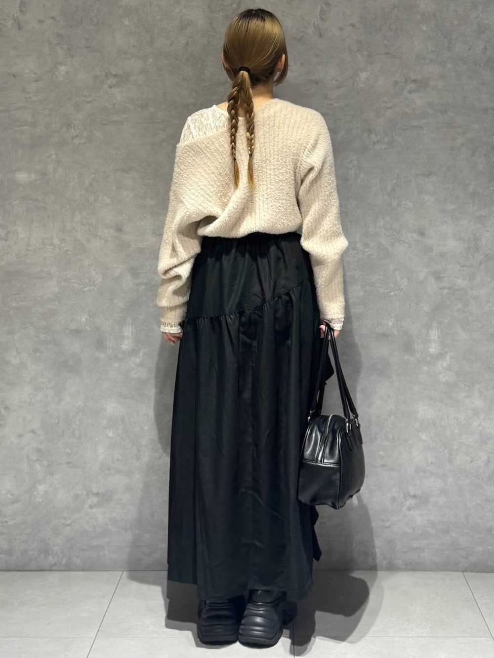 ブラック系のブーツ、ホワイト系のTシャツ/カットソー、ブラック系のボストンバッグを着用したレディースの秋コーディネートの5枚目の写真