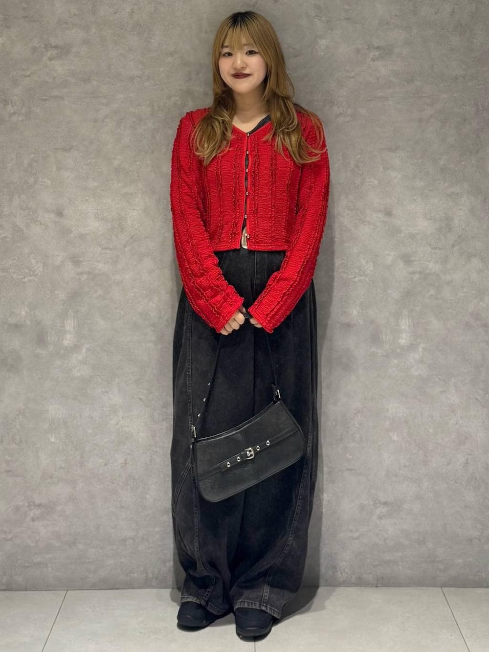 ブラック系のスニーカー、ブラック系のハンドバッグ、ブラック系のデニムパンツを着用したレディースの春コーディネートの7枚目の写真