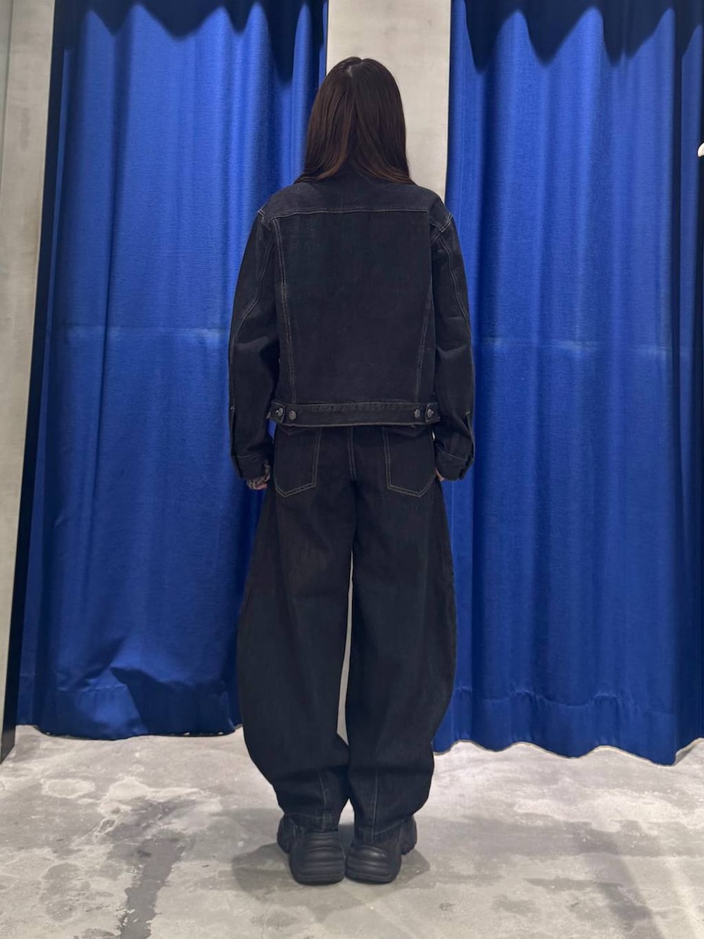 ブラック系のデニムパンツ、ブラック系のデニムジャケット、ブラック系のブーツを着用したレディースの夏コーディネートの5枚目の写真
