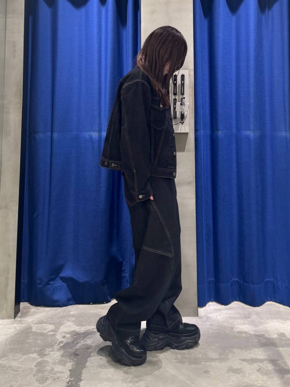 ブラック系のデニムパンツ、ブラック系のデニムジャケット、ブラック系のブーツを着用したレディースの夏コーディネートの4枚目の写真